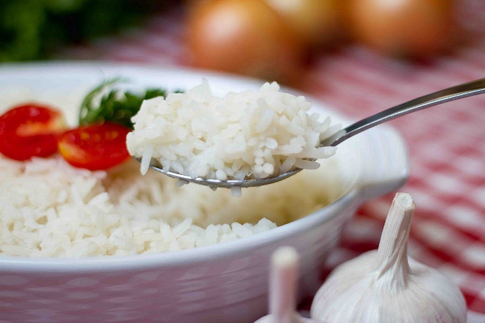 Imagem de prato de arroz soltinho e uma colher tirando uma porção.